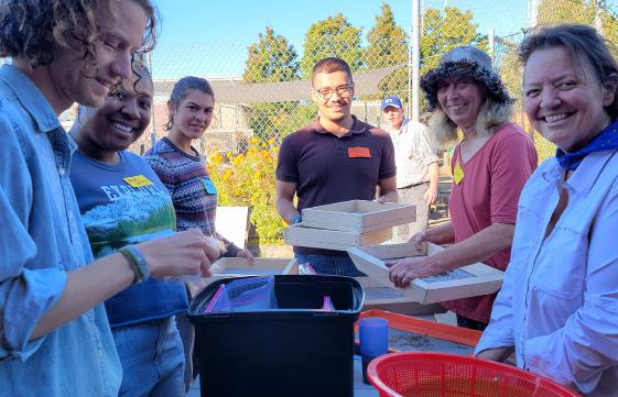 Volunteers gathered around a table cleaning and packing seed